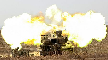 An Israeli army self-propelled howitzer fires rounds near the border with Gaza in southern Israel on October 11, 2023.