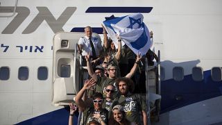 مهاجرون جدد من الولايات المتحدة يلوحون بالعلم الإسرائيلي مطار بن غوريون بالقرب من تل أبيب، إسرائيل