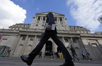 A man walks past the Bank of England, at the financial district in London, on May 11, 2023. 