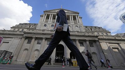 A man walks past the Bank of England, at the financial district in London, on May 11, 2023. 