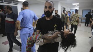 Ένας πατέρας κρατάει το τραυματισμένο παιδί του στη Λωρίδα της Γάζας