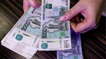An employee counts Russian 1000-rouble banknotes in a bank office in Moscow, Russia, in this illustration picture taken October 9, 2023.