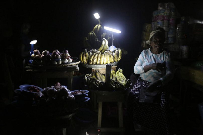 Vegetable vendors ply their wares by the light of locally-made lanterns in Lagos, February 2017