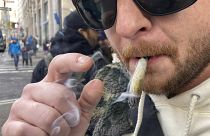 Ben Gilbert, de 38 años, fuma marihuana en el bajo Manhattan fuera del primer dispensario legal de marihuana recreativa en Nueva York el jueves 29 de diciembre de 2022.