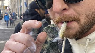 Бен Гилберт, 38 лет, курит марихуану в нижнем Манхэттене возле первого легального диспансера рекреационной марихуаны в Нью-Йорке в четверг, 29 декабря 2022 г.
