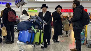 أعضاء من الجالية اليهودية الأرثوذكسية المتطرفة يدفعون أمتعتهم في مطار ستانستيد شمالي لندن. 2023/10/12