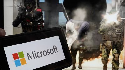 The logo for Microsoft, and a scene from Activision "Call of Duty - Modern Warfare," are shown in this photo, in New York, June 21, 2023.