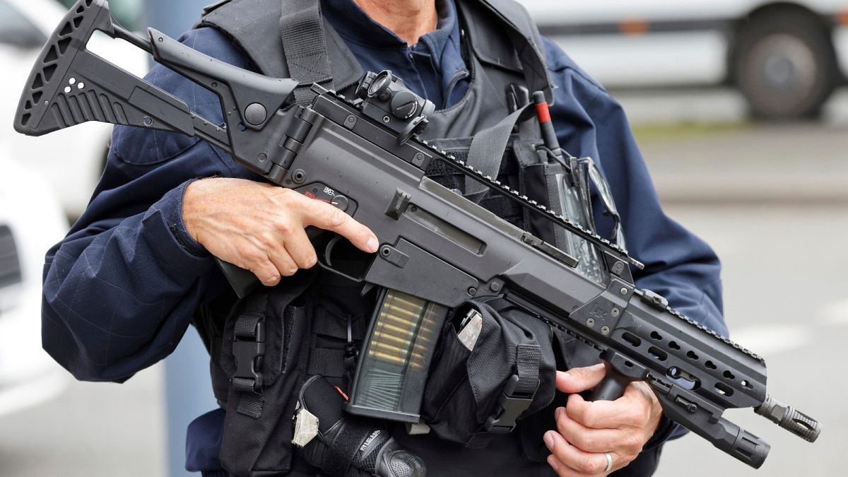 A police officer holds a HK G36 assault rifle at the Gambetta high school in Arras, northeastern France, Friday Oct. 13, 2023. 
