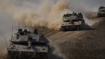 Israeli tanks head towards the Gaza Strip border in southern Israel on Friday, Oct.13, 2023.