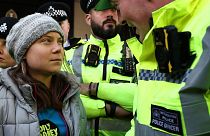 Un agente di polizia parla con l'attivista svedese per il clima Greta Thunberg.