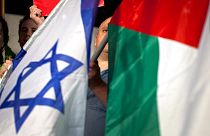 DOSSIER : Des militants israéliens de gauche brandissent des drapeaux israéliens et palestiniens pour soutenir la candidature palestinienne à l'ONU pour obtenir le statut d'État observateur, le 29 novembre 2012.