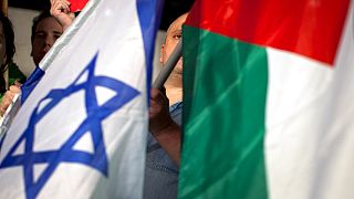 DATEI: Israelische linke Aktivisten halten israelische und palästinensische Flaggen, um die palästinensische UN-Bewerbung um den Status eines Beobachterstaates zu unterstützen, 29\. November 2012.