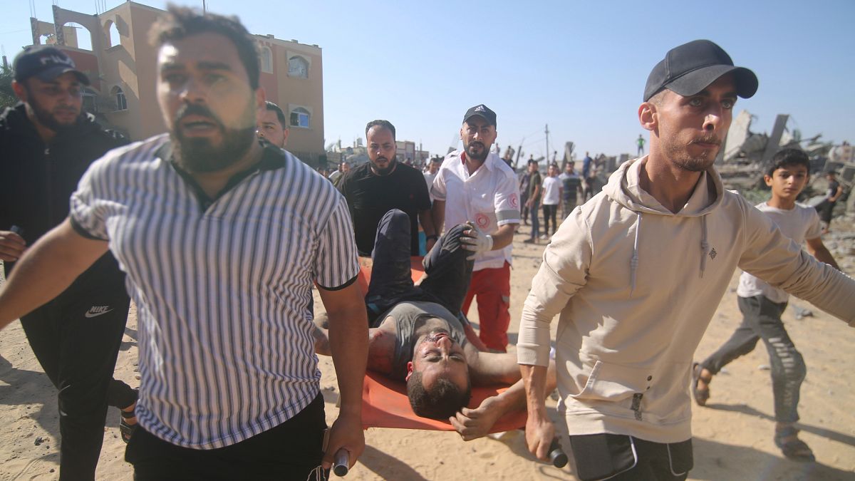 Палестинцы несут раненого в результате израильского обстрела в секторе Газа
