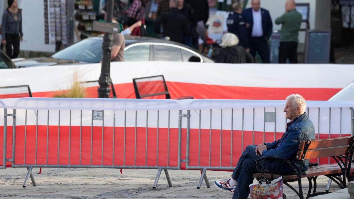 A man waits for the final election campaign rally of ruling PiS (Law and Justice) leader Jaroslaw Kaczynski, in Sandomierz, Poland, Friday, Oct. 13, 2023. 