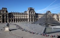 A mezőny a párizsi Louvre múzeum piramisa mellett a 109. Tour de France francia országúti kerékpáros körversenyen 2022. július 24-én – képünk illusztráció.