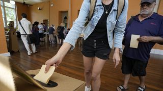 Une femme dépose son bulletin de vote dans une urne dans un bureau de vote à Redfern alors que les Australiens votent pour la dernière fois à Sydney, samedi 14 octobre 2023