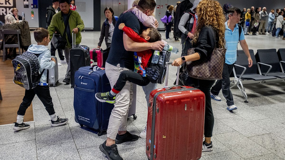 أب يحتضن أطفاله الذين تم إجلاؤهم من إسرائيل إلى ألمانيا