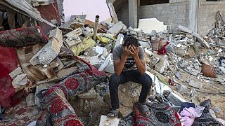 Палестинец у своего разрушенного дома после израильских ударов