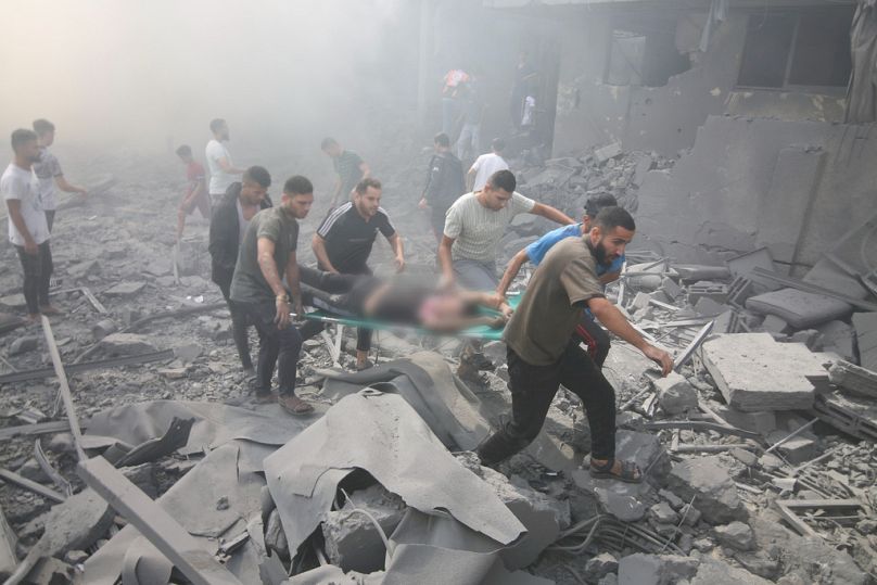 İsrail savaş uçaklarının Gazze'deki Refah Mülteci Kampı'na yönelik bombardımanında yaralanan bir Filistinli yıkıntılar arasında tahliye edilirken