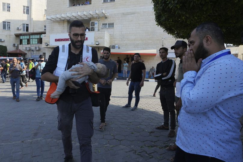 Filistinli bir sağlık görevlisi, İsrail'in Gazze Şeridi'ne düzenlediği hava saldırılarında hayatını kaybeden bir bebeğin cansız bedenini taşırken