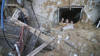 Niños palestinos observan el edificio de la familia Zanon, destruido por los ataques aéreos israelíes en Rafah, Franja de Gaza, sábado 14 de octubre de 2023.
