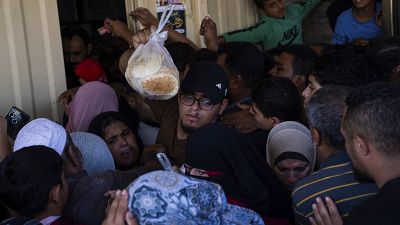 يصطف مئات الفلسطينيين أمام مخبز في خان يونس في قطاع غزة