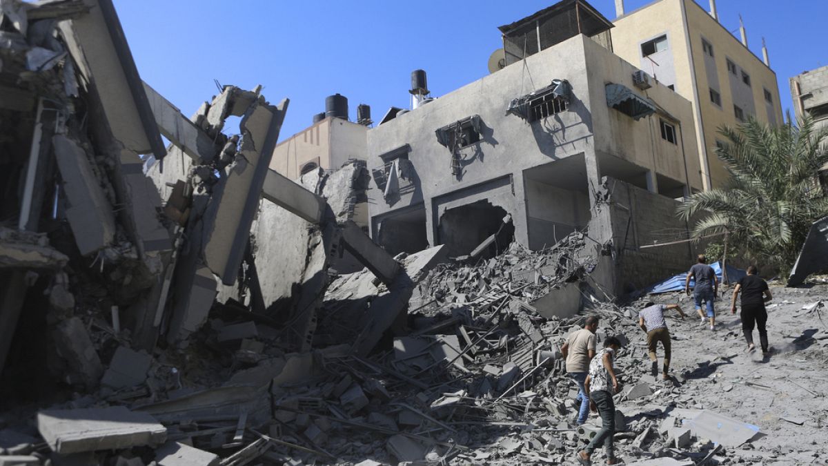 Des Palestiniens inspectent les dégâts d'un bâtiment détruit suite aux frappes aériennes israéliennes sur la ville de Gaza, au centre de la bande de Gaza, 15 octobre 2023 