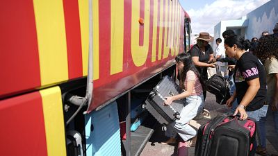Eine Bewohnerin von Sderot wuchtet einen Koffer in den Bus