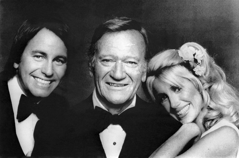 John Ritter and Suzanne Somers welcome John Wayne back to the set during the filming of "General Electric All Star Anniversary" in Los Angeles, United States, on July 10, 1978