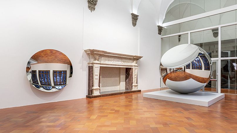Several mirror sculptures by Anish Kapoor on display at the Palazzo Strozzi.