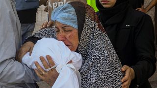 امرأة فلسطينية تبكي فوق جثمان طقل قتل جراء القصف الإسرائيلي على مدينة دير البلح في غزة
