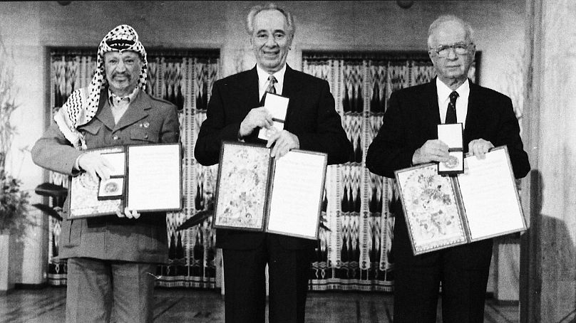 یاسر عرفات (سمت چپ)، اسحاق رابین نخست وزیر اسرائیل (وسط)، و شیمون پرز وزیر امور خارجه اسرائیل (راست) پس از دریافت جایزه صلح نوبل در سال ۱۹۹۴ در شهر اسلو