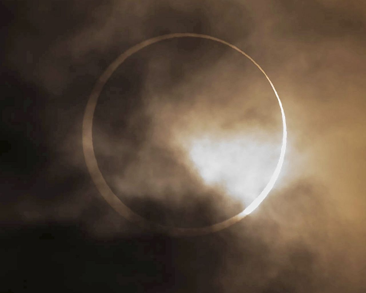 The annular solar eclipse appears from behind clouds above Skinner Butte in Eugene, Oregon, US, Saturday, October 14, 2023.