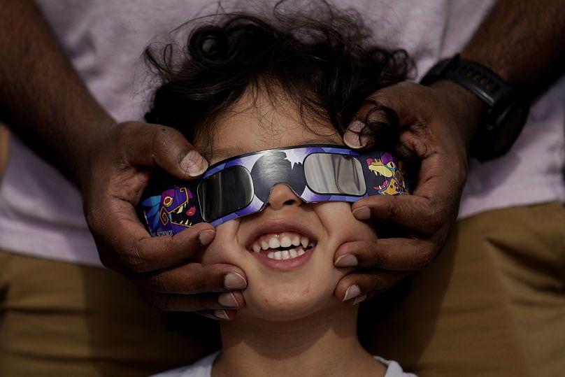 Viewers use special glasses to watch from San Antonio, as the moon moves in front of the sun during an annular solar eclipse, or ring of fire.