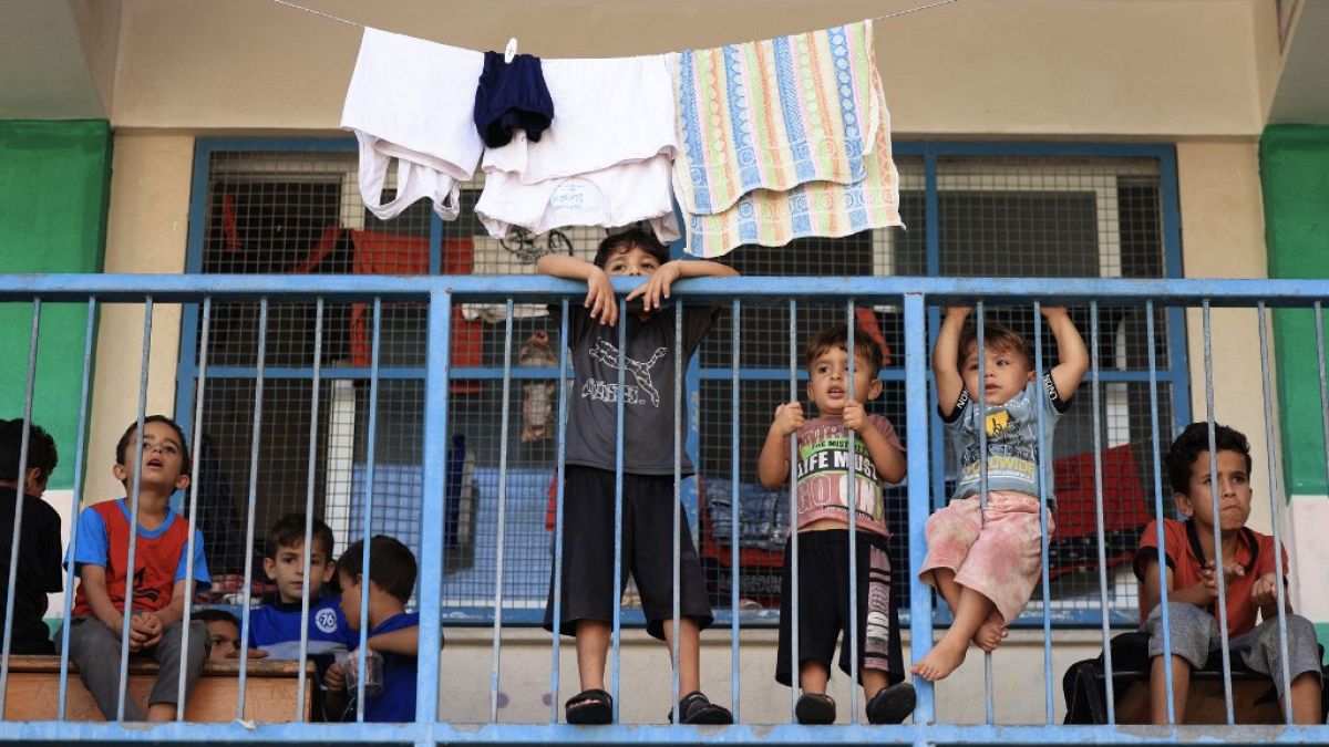 Children of internally displaced Palestinians who took refuge in a United Nations-run school gather on the balcony of a classroom in the southern of Gaza Strip city