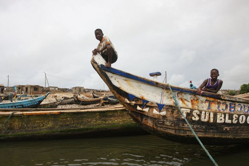 Two boys play on a fishing boat outside of Accra, May 2012