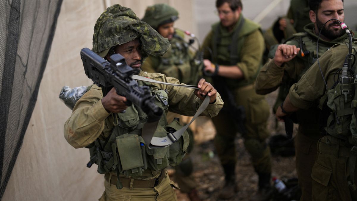 جنود إسرائيليون يستعدون للقيام بدوريات على طول طريق بالقرب من الحدود بين إسرائيل ولبنان، الاثنين، 16 أكتوبر 2023