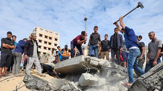 Palestinians look for survivors in buildings destroyed by Israeli airstrikes in Deir el-Balah, southern Gaza Strip