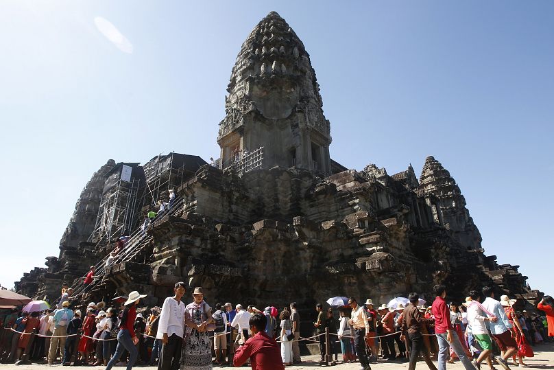 Tourists line up for stepping up Angkor Wat temple outside Siem Reap, Cambodia.