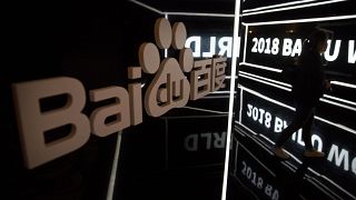  Посетител минава около екран на конференцията Baidu World в Пекин 
