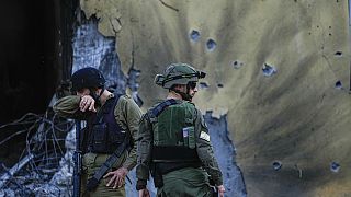 Izraeli katonák a Hamász fegyveresei által lerombolt házak mellett az izraeli Be'eri kibucban 2023. október 14-én