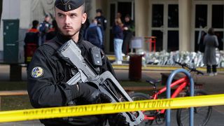 شرطي فرنسي يقف أمام المدرسة التي حدث فيها الاعتداء بمدينة أراس الفرنسية