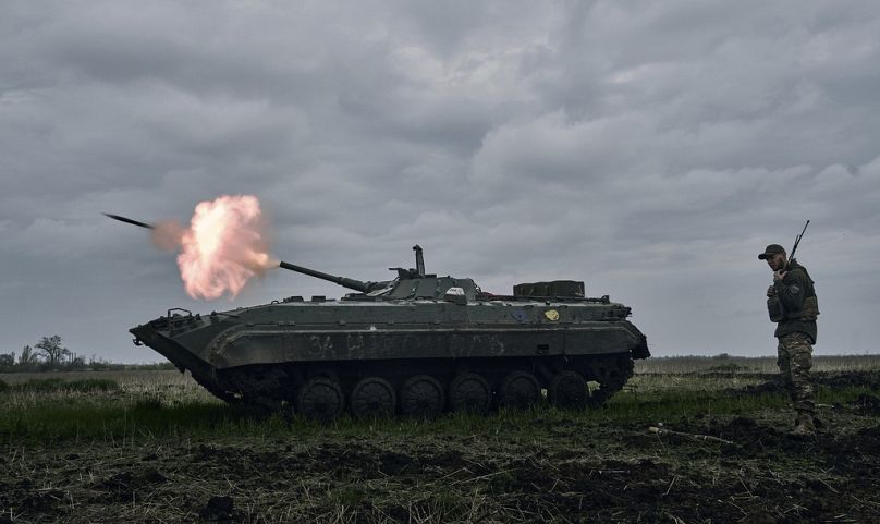 A Ukrainian APC fires towards Russian positions near Avdiivka