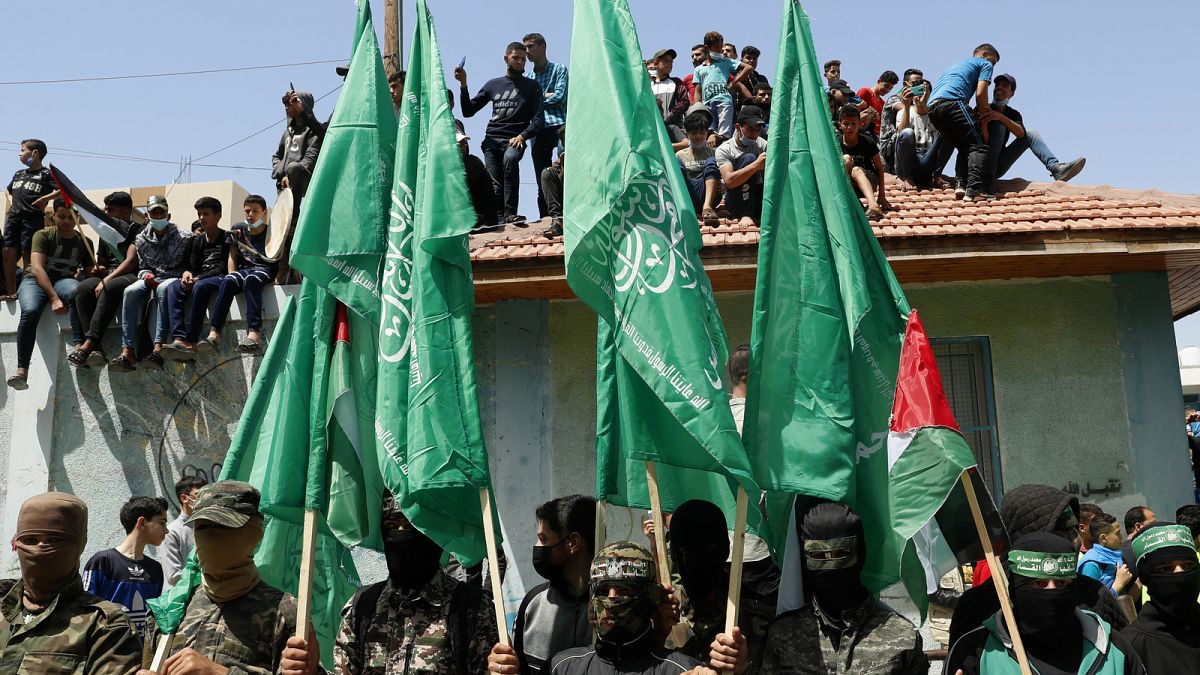 Militanti di Hamas mascherati sventolano bandiere verdi islamiche durante una manifestazione di solidarietà con i compagni palestinesi a Gerusalemme, (30.4.2021)