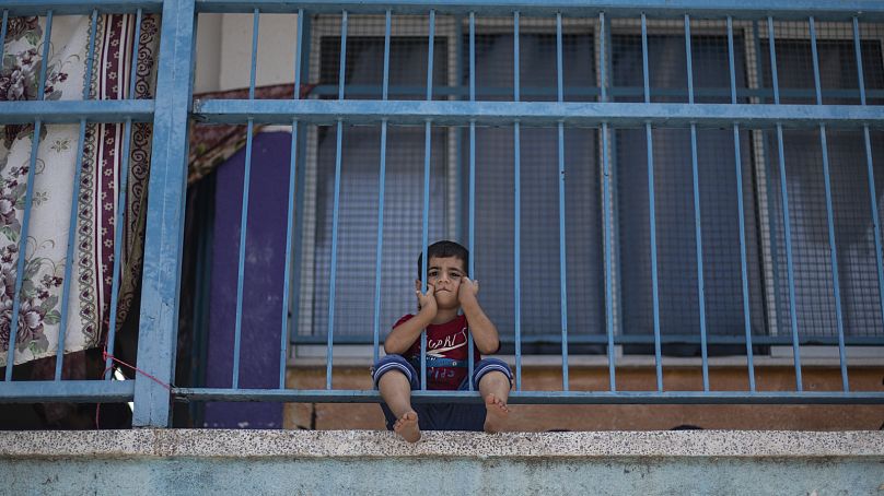 Um menino palestiniano abriga-se numa escola da ONU após a sua casa ter sido destruída por ataques aéreos israelitas durante a guerra de 11 dias, em 2021
