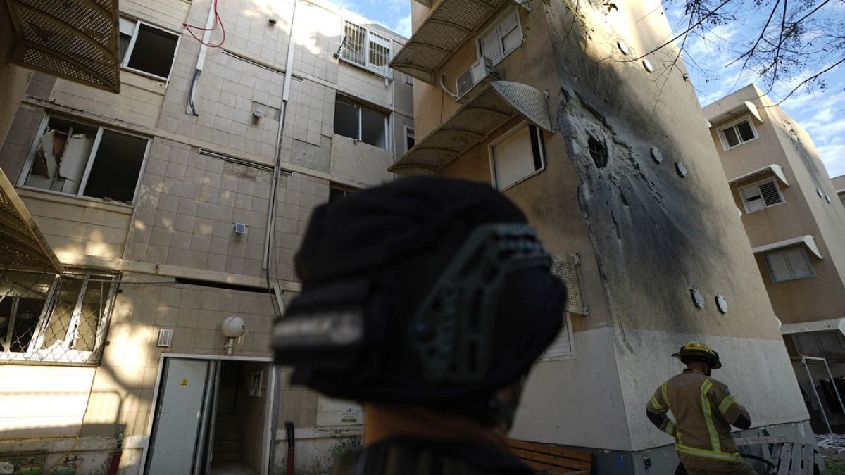 Israeli security forces inspect a damaged residential building after it was hit by a rocket fired from the Gaza Strip.
