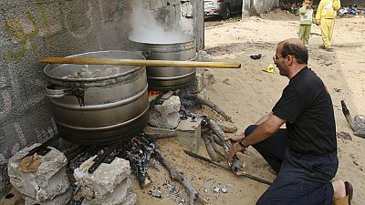 رجل يحذر الطعام لتقديمه للعائلات النازحة في غزة