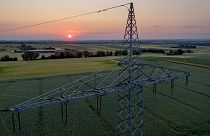 Un pylône de transmission se dresse dans un champ à la périphérie de Francfort, en Allemagne, alors que le soleil se lève le 6 juin 2023\. 