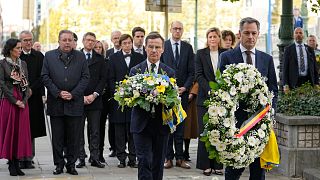 Sweden's Prime Minister Ulf Kristersson, center, and Belgium's Prime Minister Alexander De Croo, center right, carry floral tributes. 18 October 2023