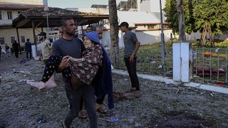 رج يحمل امرأة مسنة في مستشفى الأهلي الذي استهدف بالقصف الإسرائيلي ليل الثلاثاء. 2023/10/18